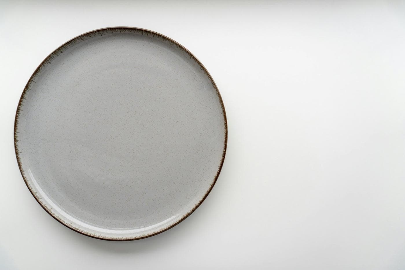 Assiette plate en grès émaillé au bord brun