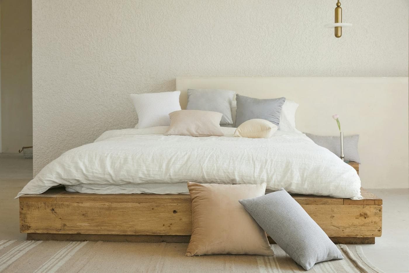 Lit fait avec une parure en lin blanc et des coussins